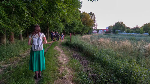 Rear view of woman walking on grassland