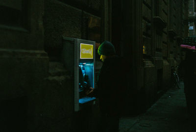 Man on illuminated street in city at night