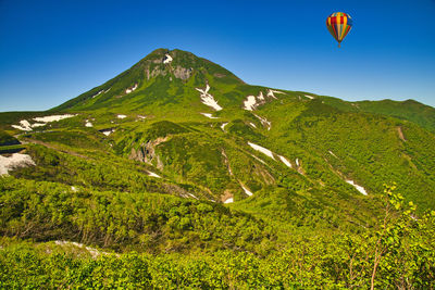 Hot air balloons on mountain against sky