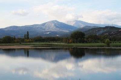 Scenic view of calm lake against cloudy sky