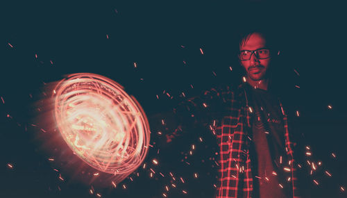 Young man playing with wire wool at night