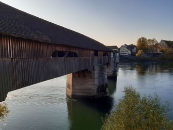 Scenic view of river by building against clear sky