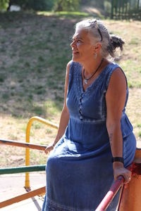 Woman looking away while sitting outdoors