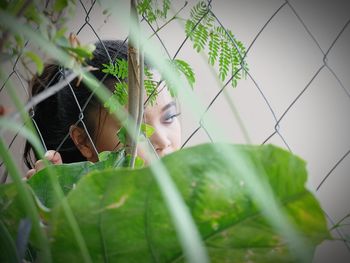 Close-up of young woman against plants