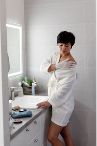 Portrait of young woman standing in bathroom