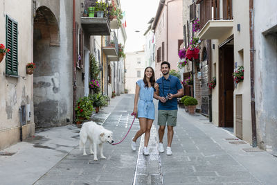 Woman with dog walking on street