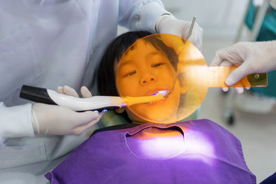 Midsection of dentist holding dentures