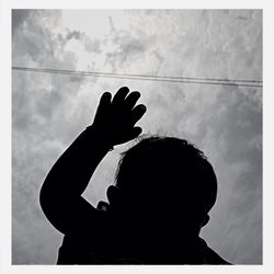 Low angle view of people against cloudy sky
