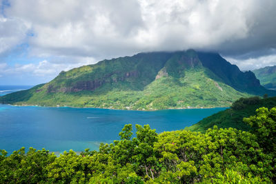 Scenic view of sea and mountains against sky