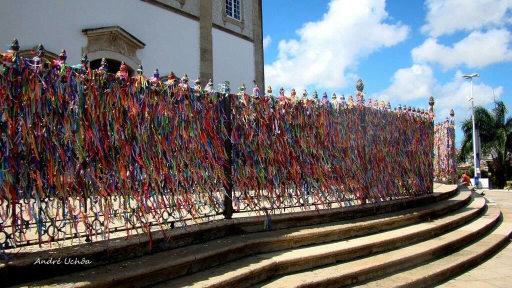 architecture, built structure, building exterior, sky, city, multi colored, railing, fence, incidental people, tree, street, outdoors, road, day, growth, sidewalk, city life, in a row, sunlight, flower