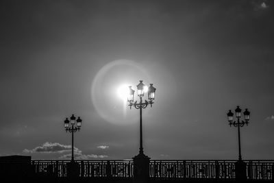 Low angle view of illuminated street lights against sky