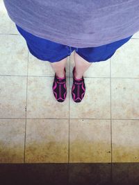 Low section of woman standing on tiled floor