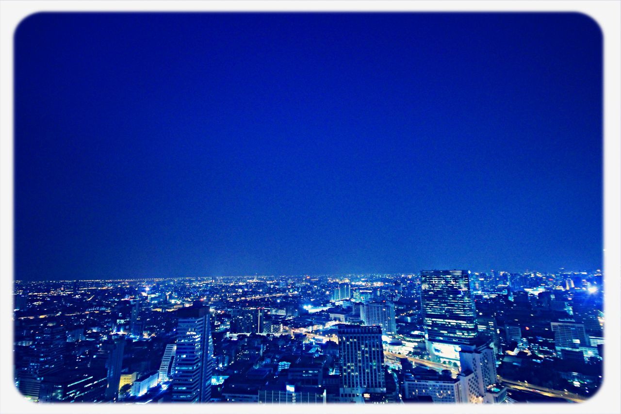transfer print, cityscape, city, copy space, clear sky, building exterior, architecture, built structure, auto post production filter, crowded, illuminated, blue, high angle view, night, city life, residential district, skyscraper, residential building, outdoors, no people