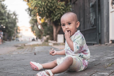 Portrait of cute girl sitting outdoors