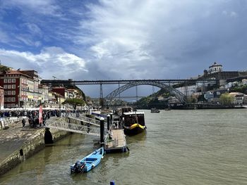 Bridge over river against cloudy sky