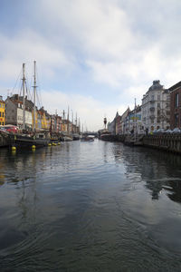 River by cityscape against sky