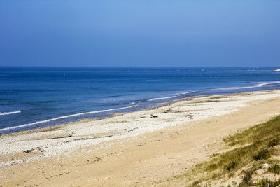 Scenic view of beach against clear blue sky