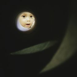 Portrait of boy seen through pipe