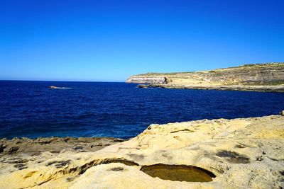 Scenic view of sea against clear blue sky