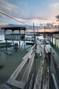 Pier on sea against sky during sunset