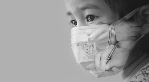 Double exposure of girl wearing mask and scientist working at laboratory