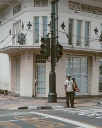 Full length of man walking on street against buildings