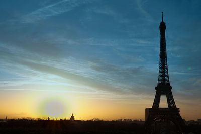 Silhouette of buildings against cloudy sky