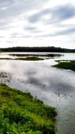 Scenic view of lake against cloudy sky