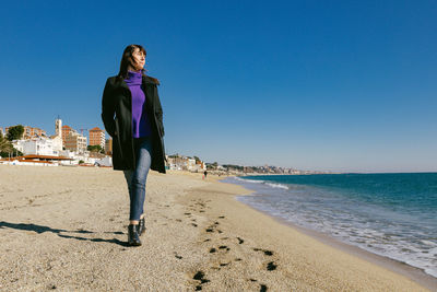 Mature woman walking on the beach on a sunny winter day