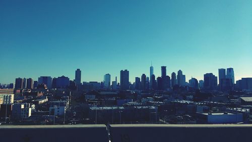 Buildings in city against clear blue sky