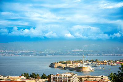 High angle view of townscape by sea against sky