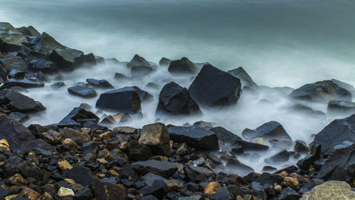 Scenic view of rocks in sea against sky