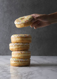 Close-up of hand holding stack on table