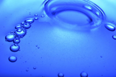 Close-up of water drop on blue surface