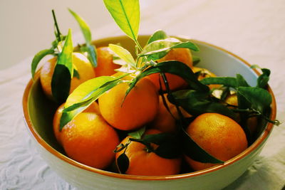 Close-up of orange fruits in bowl on table