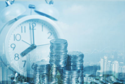 Close-up of illuminated clock tower against buildings in city