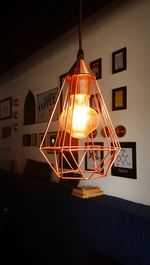 Low angle view of illuminated light bulbs hanging at night