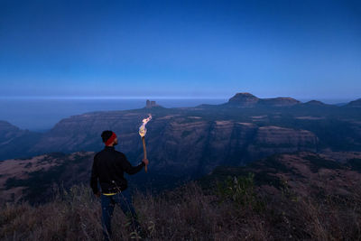 Rear view of man standing on mountain
