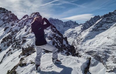 Side view of woman standing on snowcapped mountain