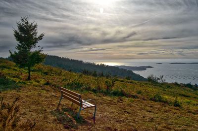 View of calm beach against cloudy sky