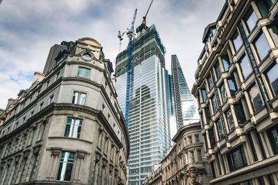 Low angle view of buildings against cloudy sky