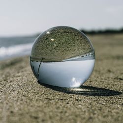 Close-up of crystal ball on beach