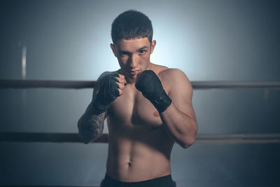 Young man exercising against wall