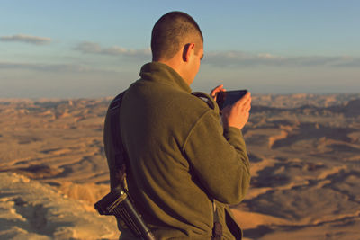 Rear view of man standing against sky