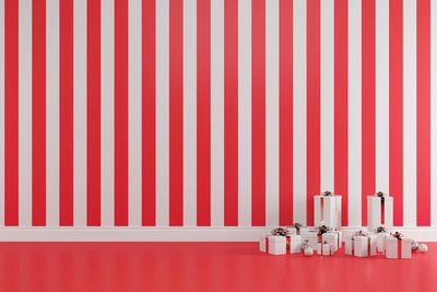 Christmas gift boxes against striped pattern wall