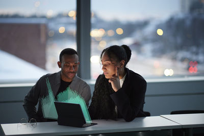 Two young business people working together in office