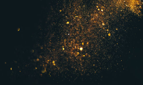 Close-up of gold glitter against black background