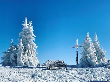 Snow on landscape against clear blue sky