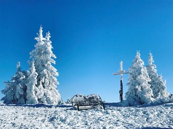 Snow on landscape against clear blue sky