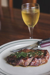 Close-up of meat and drink in plate on table